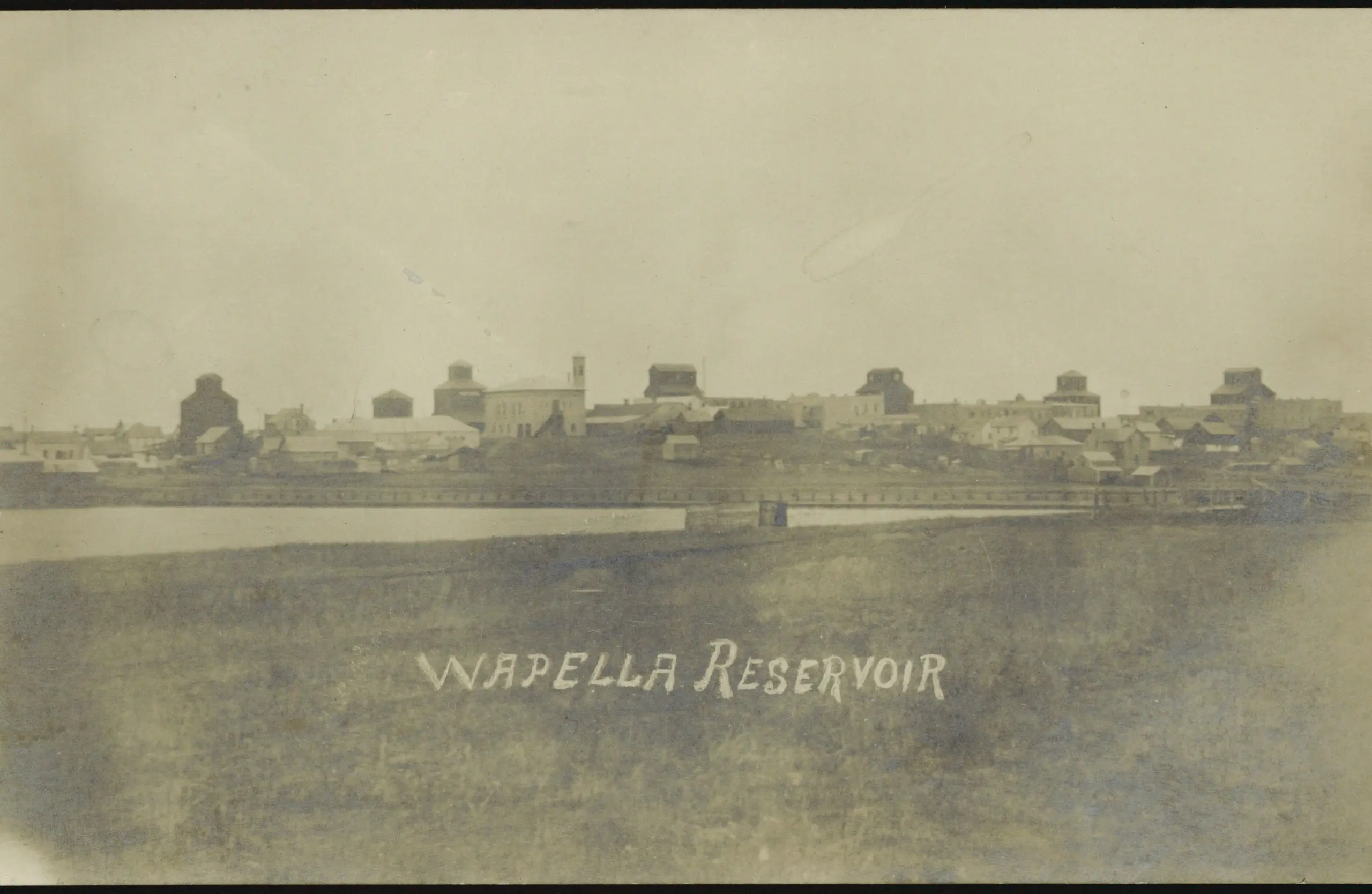 Wapella reservoir with town and grain elevators beyond